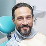 Older man in dental chair smiling