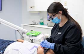 A dentist using a camera to examine a patient’s mouth