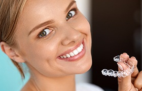 Woman holding Invisalign tray