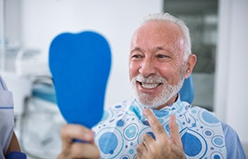 Senior man smiling while looking at his reflection