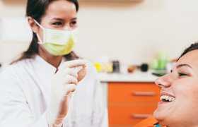 Dentist holding a tooth up to a patient