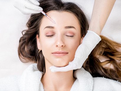 Woman receiving a dermal filler injection above her brow