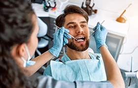 Dental hygienist in New Bedford performing gum disease treatment with instruments