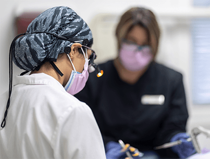 Woman in dental chair holding cheek