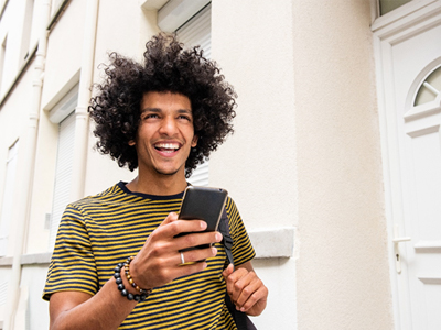 person smiling and using their phone