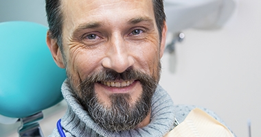 Older man in dental chair smiling