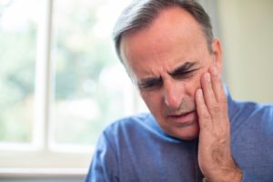 man with sore jaw needing an emergency dentist