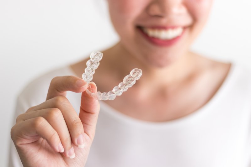 girl holding Invisalign aligner