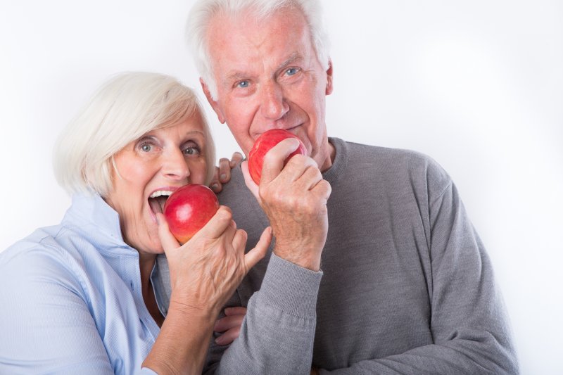 older couple with dentures eating apples