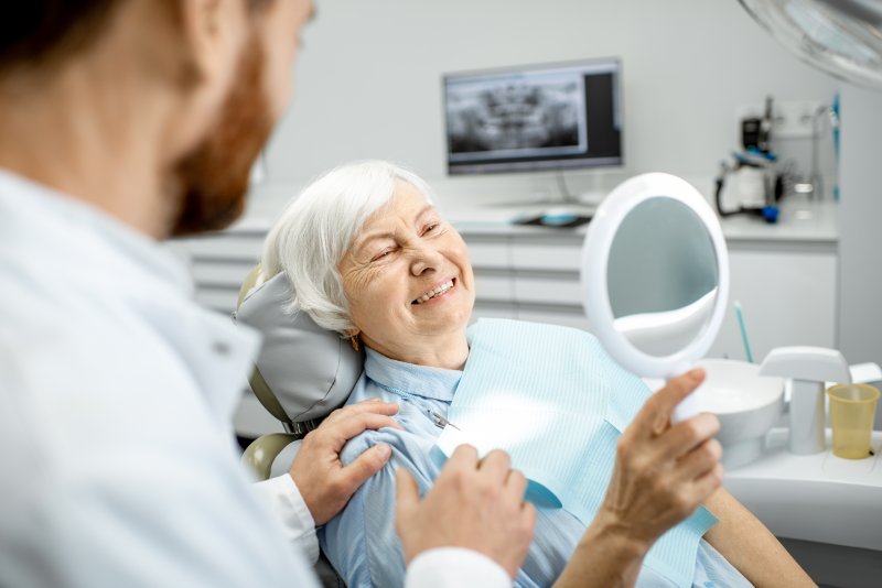 woman getting dental checkup with dentures in New Bedford