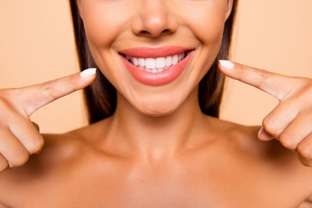 Woman pointing to her smile after receiving a smile makeover.