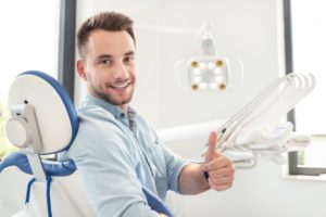 smiling man giving a thumbs up in the dental chair 